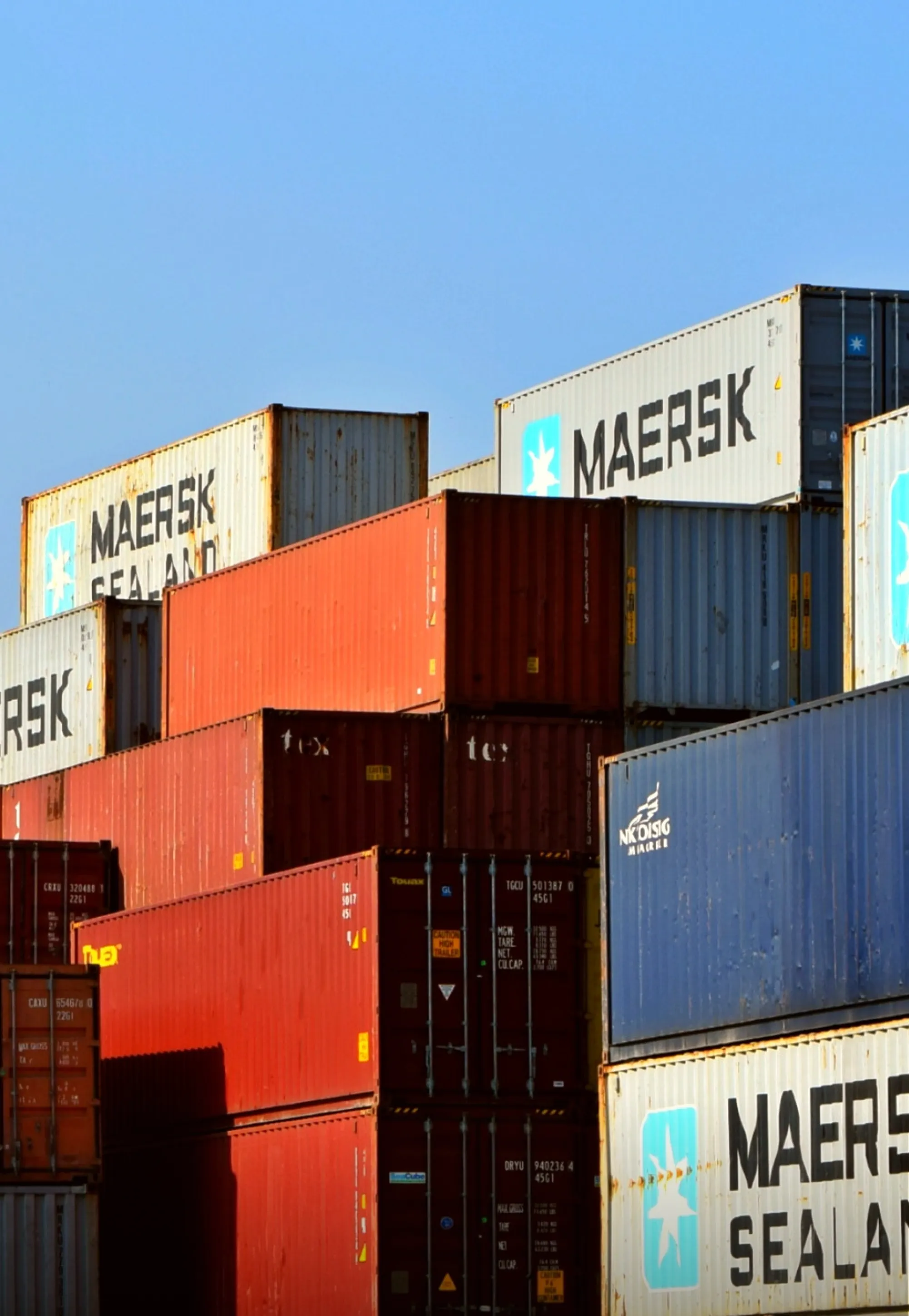 An afternoon image of containers stacked against and on top of each other.